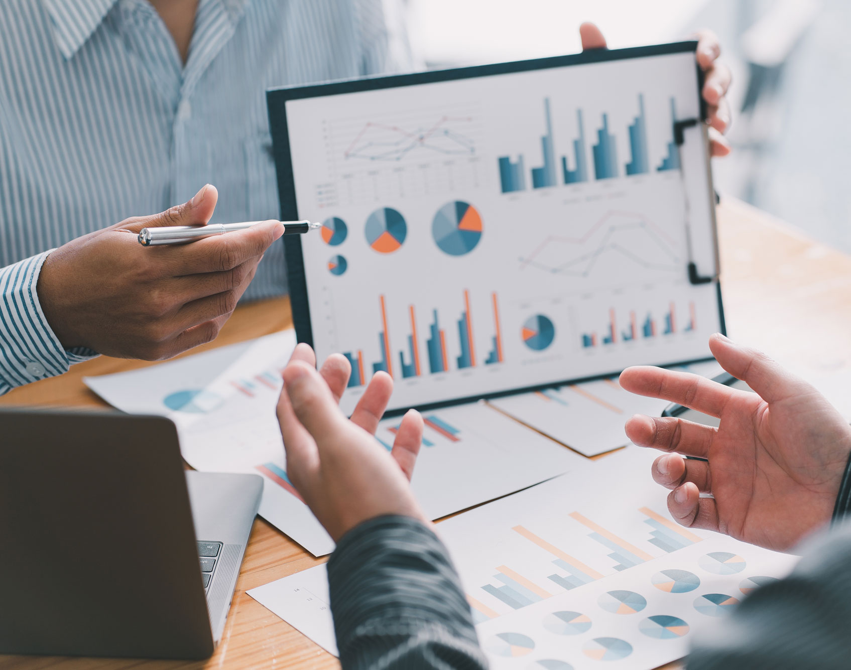 Business professionals analyzing performance metrics and KPIs from charts and graphs during a strategy meeting, emphasizing data-driven decision-making for growth.